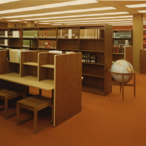 Study carrels, globe, and library stacks with bound volumes