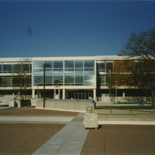 Red brick and tan stone building with bank of windows