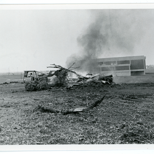Bulldozer pushing logs onto burning pile