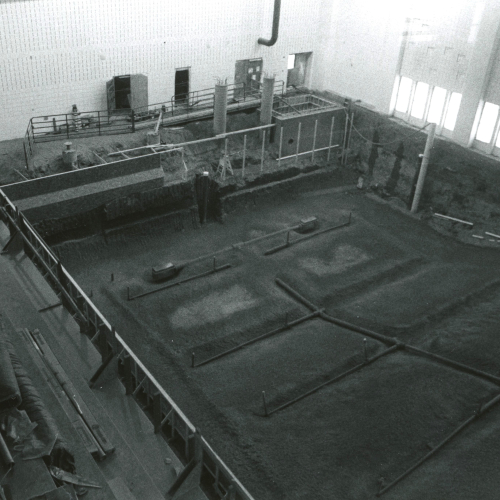 Dug-out rectangular area inside a building with piping around the edges