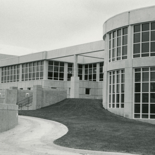 A limestone building with curved facade on the right and many windows along its length