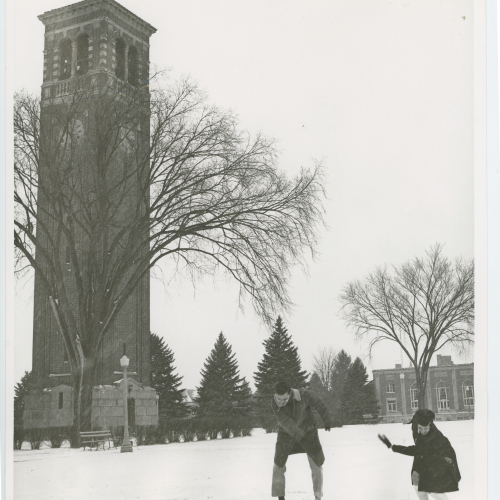Two people throwing snowballs beside Campanile
