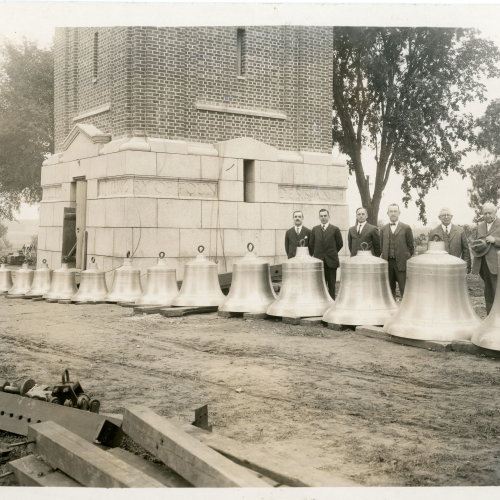 15 bells and 6 men lined up in front of Campanile