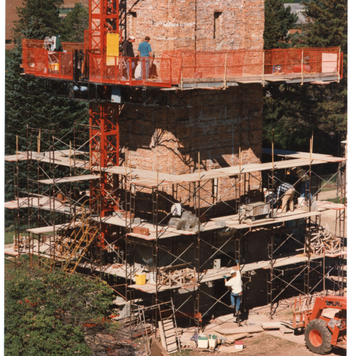 Workers on platformed scaffolding working on Campanile brick