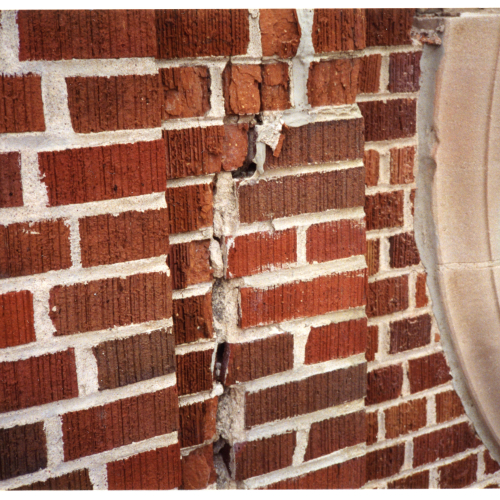 Close-up of damaged brickwork on Campanile near clock face
