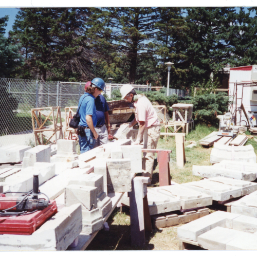 Masons shaving pieces of limestone on the ground