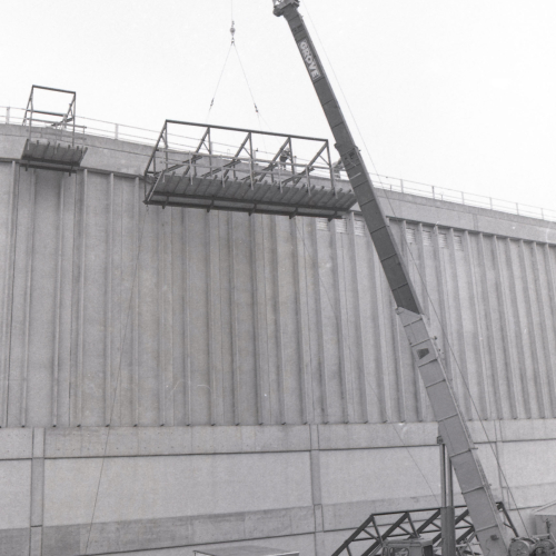 Crane parked next to building with sides but no roof