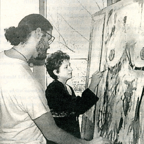 Two students painting by the window during a brief power outage, 1998