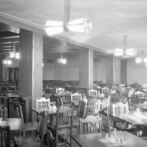 Empty square tables with four chairs each and condiment containers filling a large room