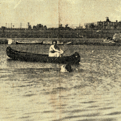 Clara Mae Rath swimming in the pond while Lois Bragonier stays in a canoe